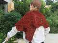 model wearing dark red Feuille-morte shawl wrapped around shoulders, closeup of twisted stitch lace texture