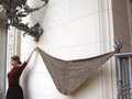 large Alfarería shawl suspended between finial and model's hand, to show flat shape