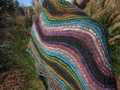 detail of larger Rosita shawl wrapped around shoulders to show off the wavy stripes, with model's back facing camera