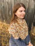 speckled Feuille-morte shawl wrapped around shoulders viewed from the side, showcases center panel of shawl on shoulder